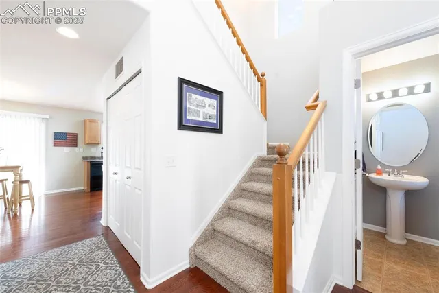 a view of a hallway with wooden floor and staircase