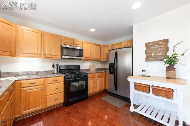 a kitchen with stainless steel appliances granite countertop a refrigerator a stove top oven a sink and dishwasher