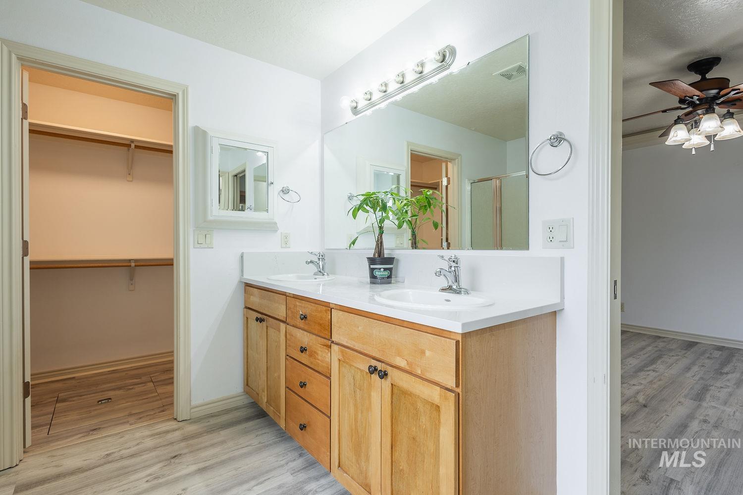 4227 North Rhodes Avenue Meridian, ID 83646 - Photo 19 of 42 Bathroom with double vanity, ceiling fan, light wood finished floors, and a walk in closet