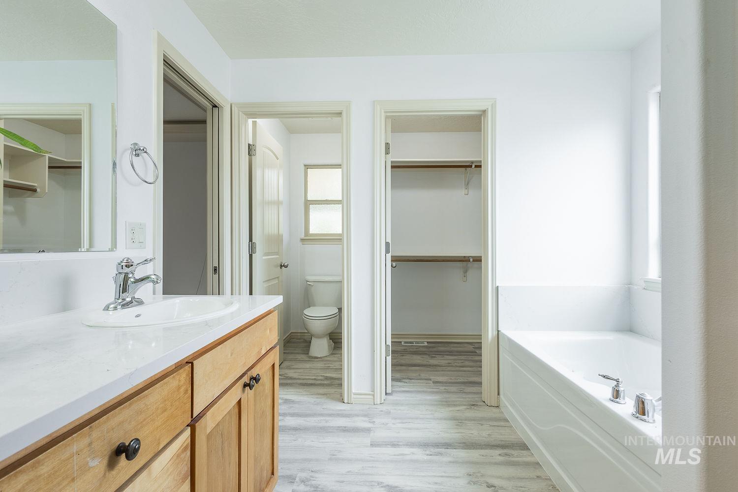 4227 North Rhodes Avenue Meridian, ID 83646 - Photo 22 of 42 Full bath featuring a spacious closet, vanity, a garden tub, and light wood-style floors