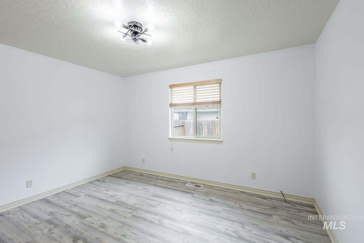 4227 North Rhodes Avenue Meridian, ID 83646 - Photo 32 of 42 Unfurnished room with a textured ceiling and light wood finished floors