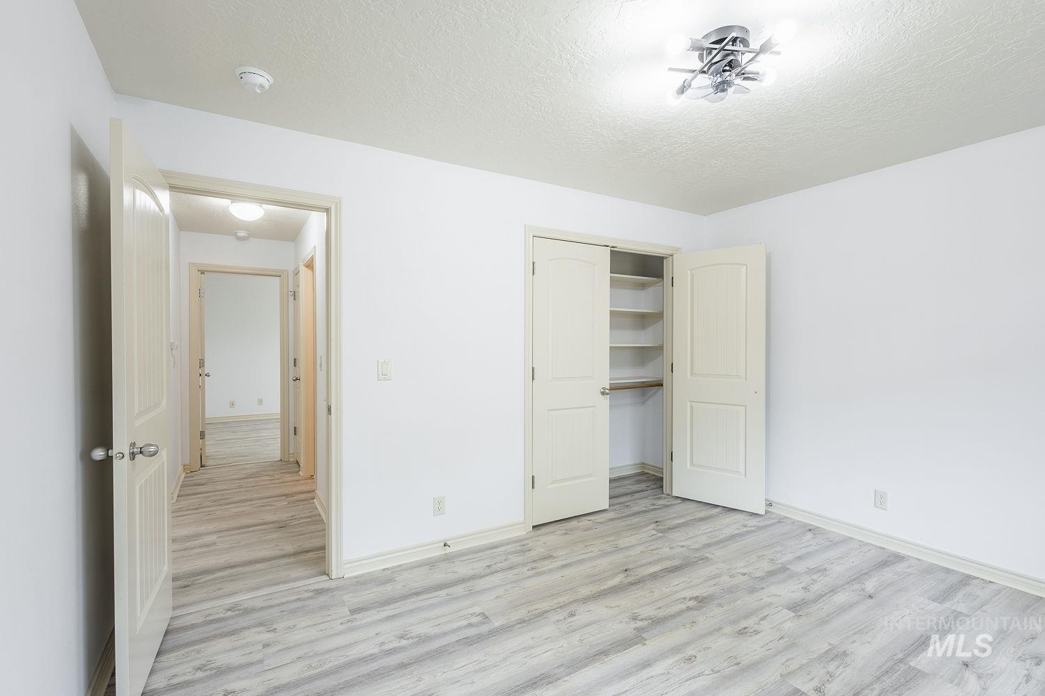 4227 North Rhodes Avenue Meridian, ID 83646 - Photo 33 of 42 Unfurnished bedroom with a textured ceiling, light wood-style flooring, and a closet