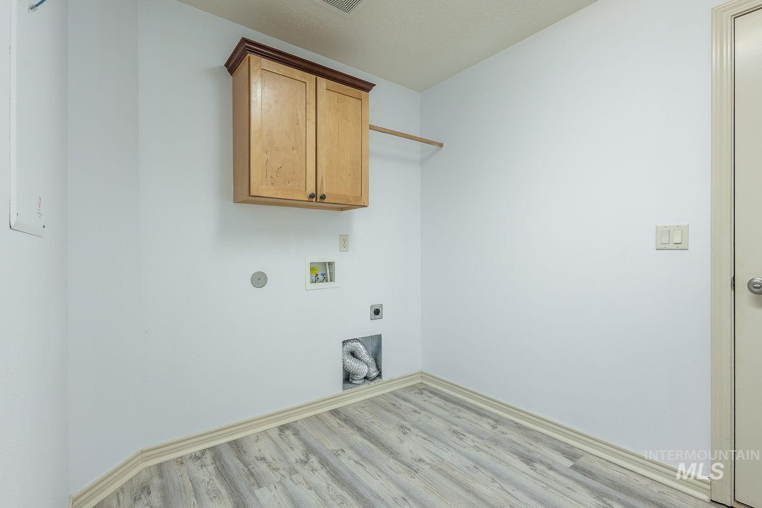 4227 North Rhodes Avenue Meridian, ID 83646 - Photo 37 of 42 Laundry room with electric dryer hookup, washer hookup, light wood-type flooring, and cabinet space