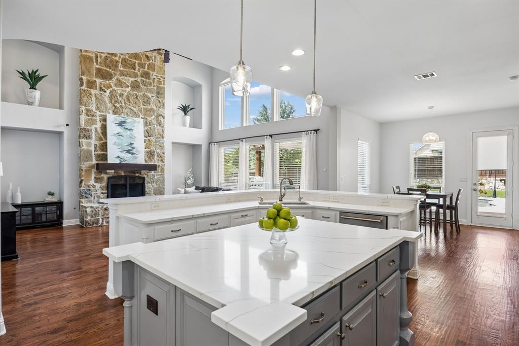 1011 Three Rivers Drive Prosper, TX 75078 - Photo 24 of 27 a kitchen with stainless steel appliances granite countertop a sink a stove and a wooden floors