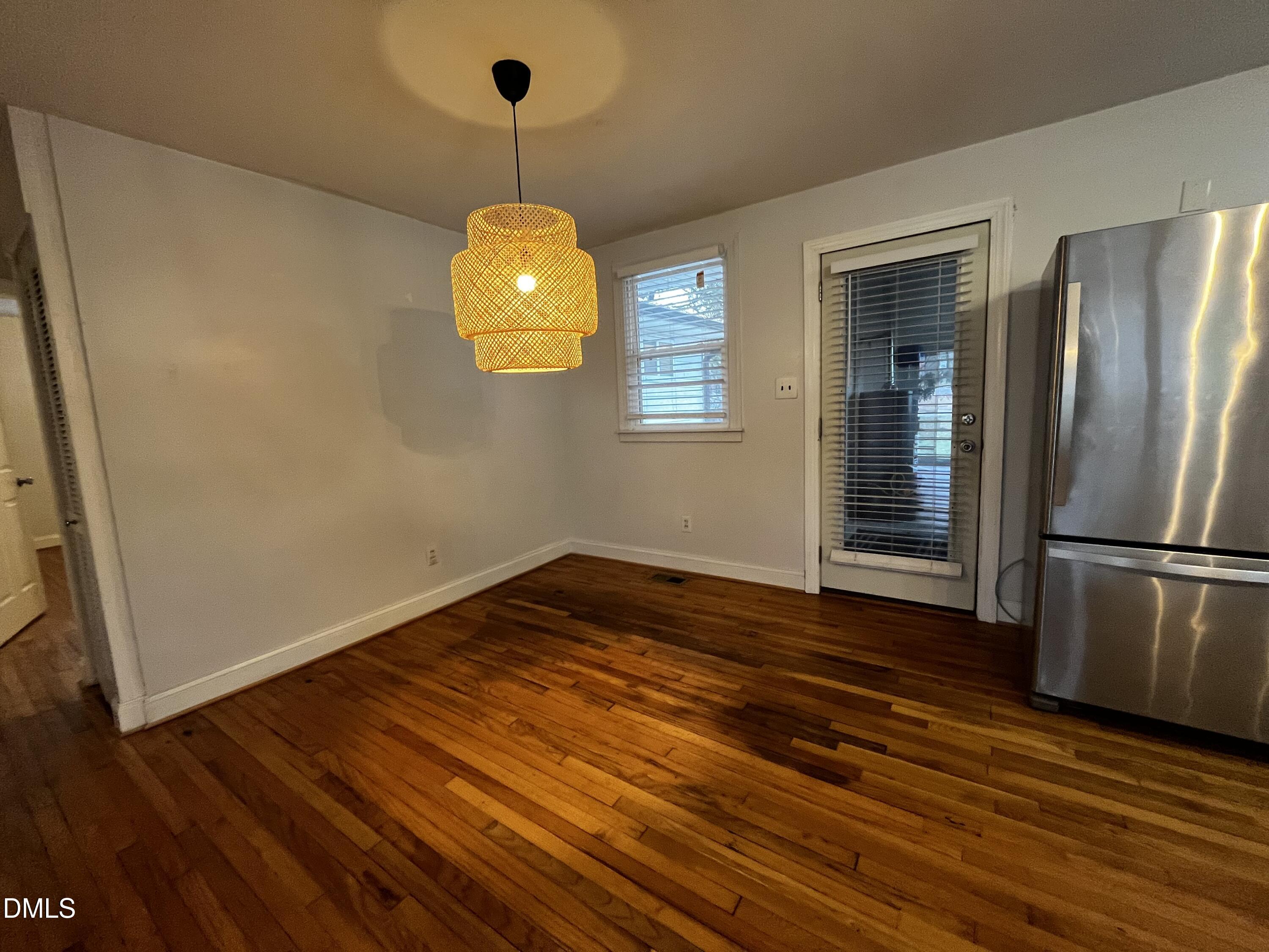 712 Hadley Road Raleigh, NC 27610 - Photo 4 of 11 a view of an empty room with wooden floor and a window