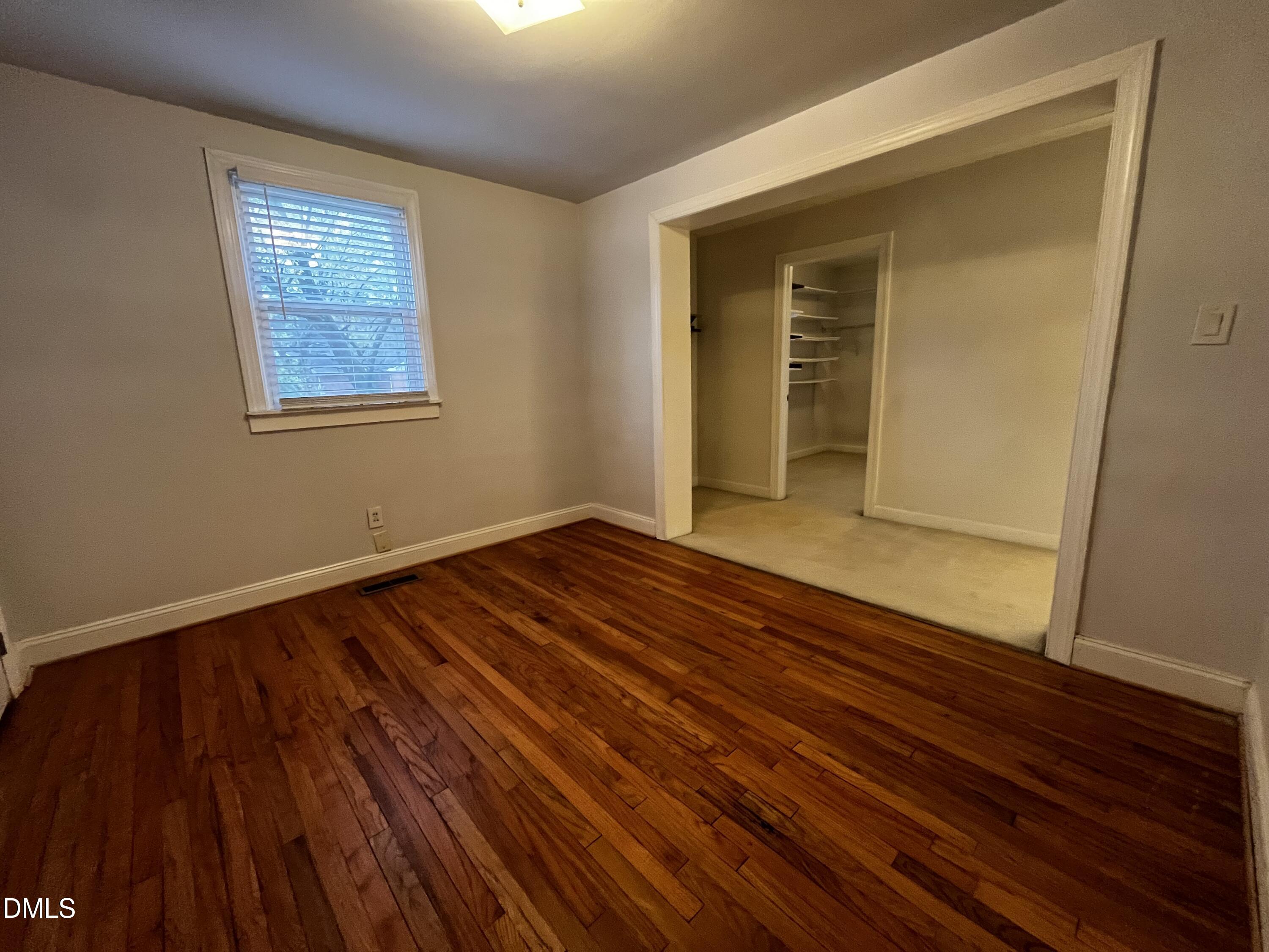 712 Hadley Road Raleigh, NC 27610 - Photo 6 of 11 a view of an empty room with wooden floor and a window