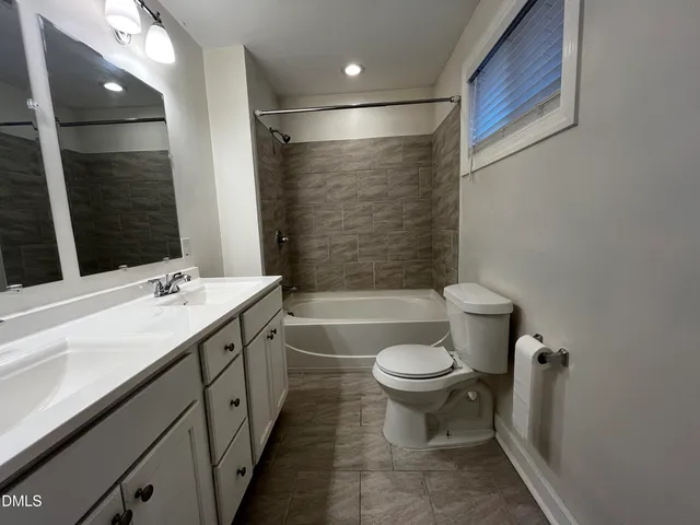 a bathroom with a double vanity sink toilet and shower