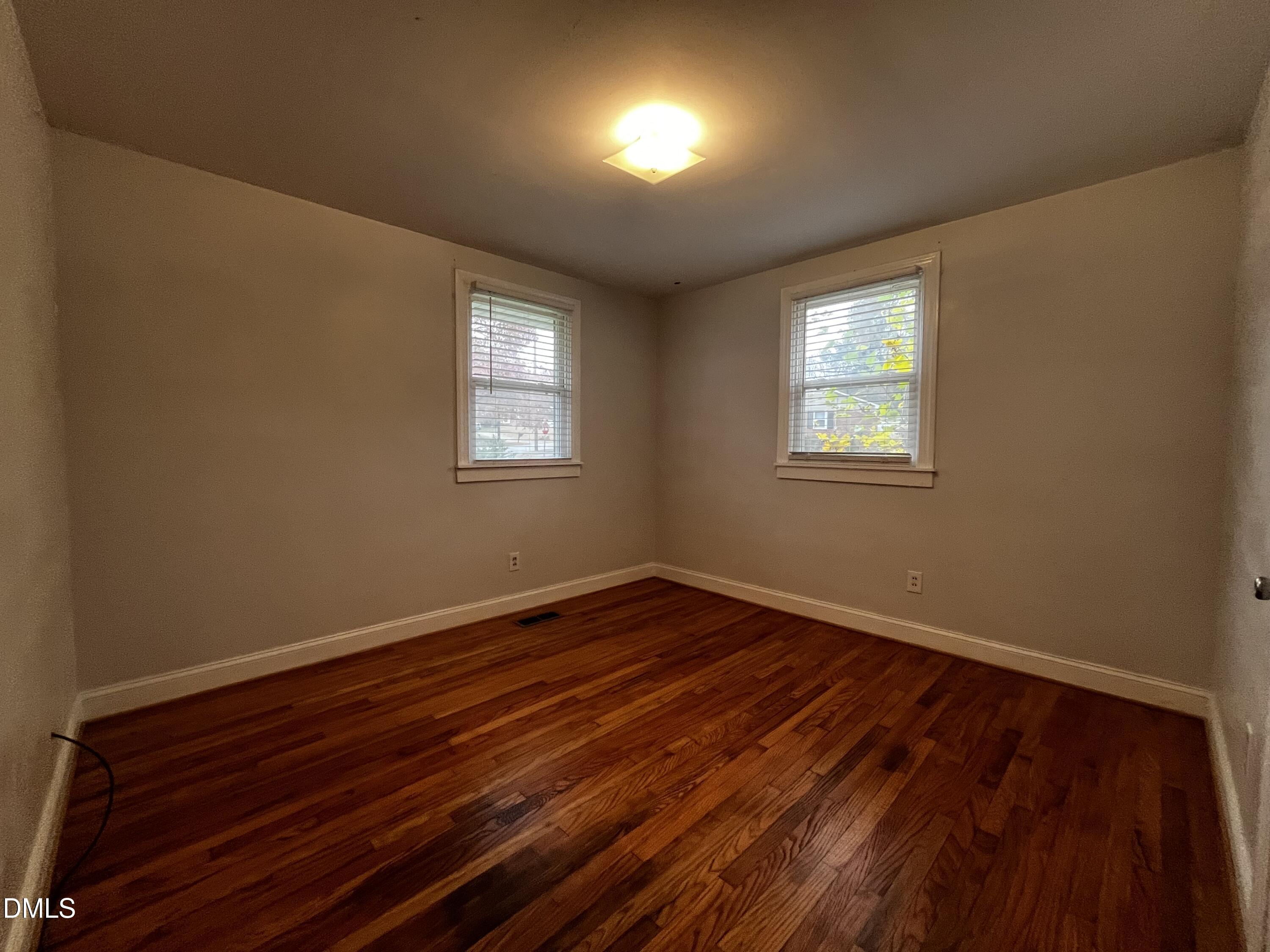 712 Hadley Road Raleigh, NC 27610 - Photo 9 of 11 a view of an empty room with wooden floor and a window