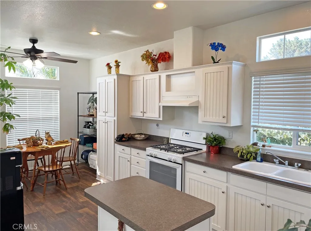 449 West Tefft Street, Unit 39 Nipomo, CA 93444 - Photo 5 of 17 a kitchen with stainless steel appliances a stove a sink dishwasher and white cabinets with wooden floor