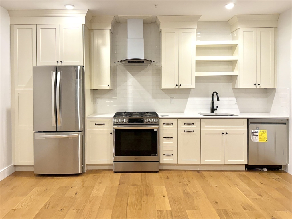 a kitchen with a refrigerator sink and cabinets