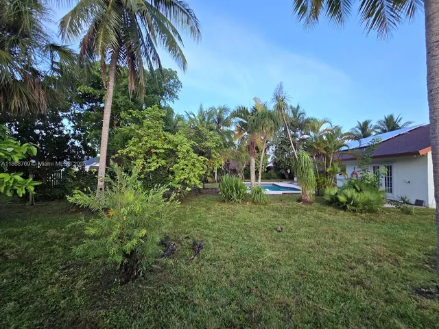 a view of a house with a yard and potted plants