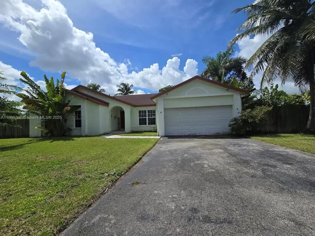a front view of a house with a garden and trees