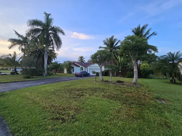 a front view of house with yard and green space