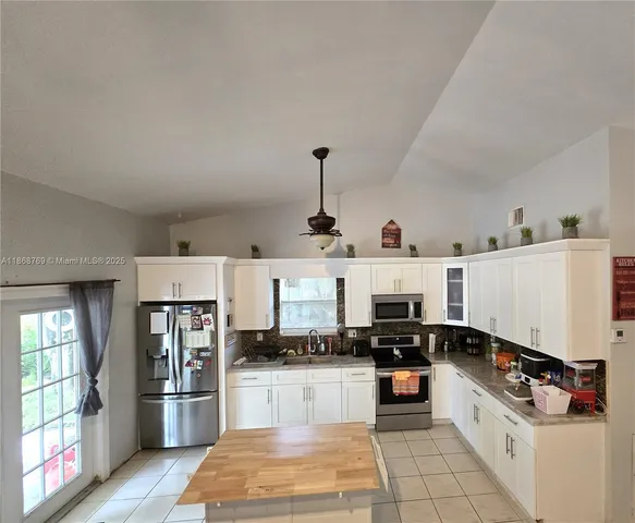 a kitchen with stainless steel appliances a refrigerator and stove top oven