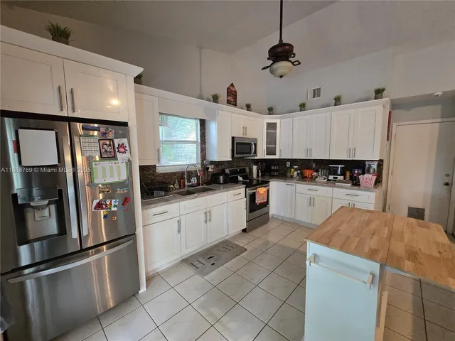 a kitchen with granite countertop stainless steel appliances and white cabinets