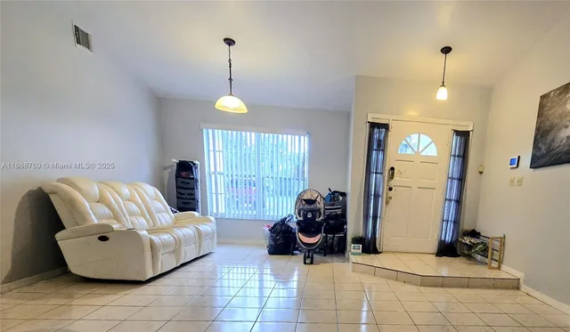 a living room with furniture and a chandelier