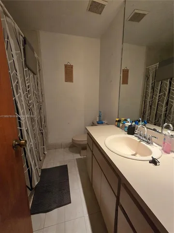 a view of a house with a yard and palm trees