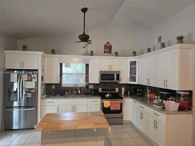 a kitchen with stainless steel appliances granite countertop a refrigerator sink and stove