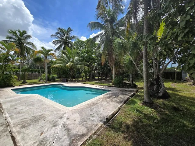 a view of a backyard with swimming pool