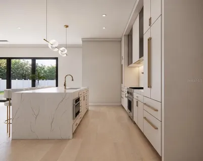 a large white kitchen with a large window a sink and a stove