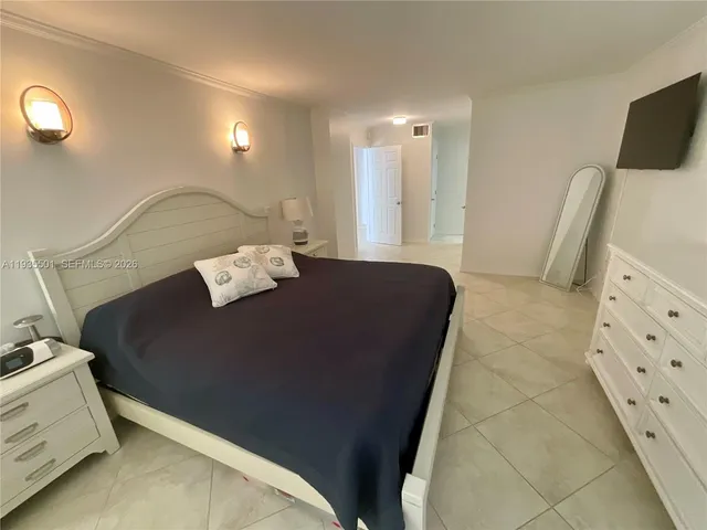 a bed sitting in a room next to a lamp