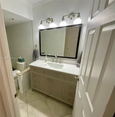 a bathroom with a sink and mirror with bathtub