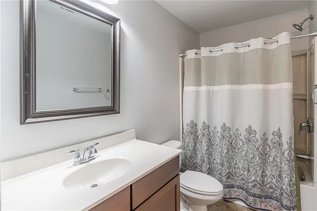 a bathroom with a sink vanity mirror and toilet
