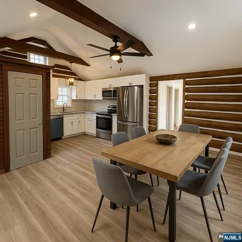 a kitchen with stainless steel appliances kitchen island granite countertop a table chairs and wooden floor