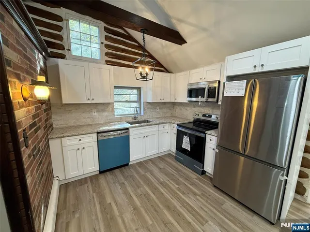 a kitchen with stainless steel appliances a refrigerator sink and microwave