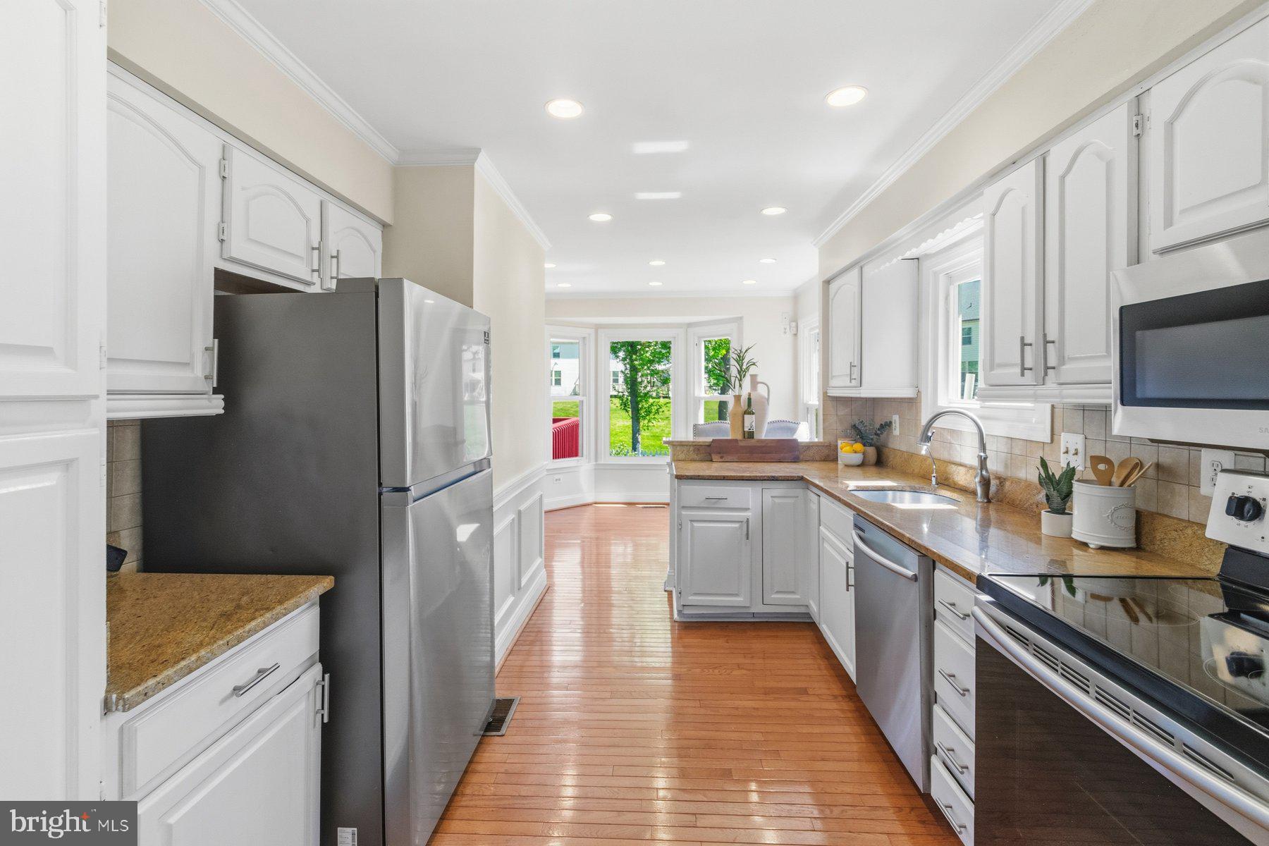 14215 Greenview Drive Laurel, MD 20708 - Photo 10 of 35 a kitchen with granite countertop a refrigerator stove top oven and sink