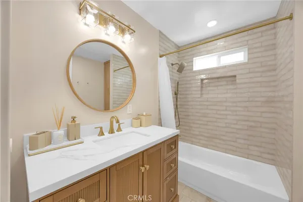 a bathroom with a sink vanity mirror and a bathtub