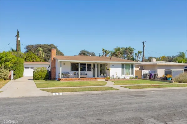a view of a big house with a big yard and large trees