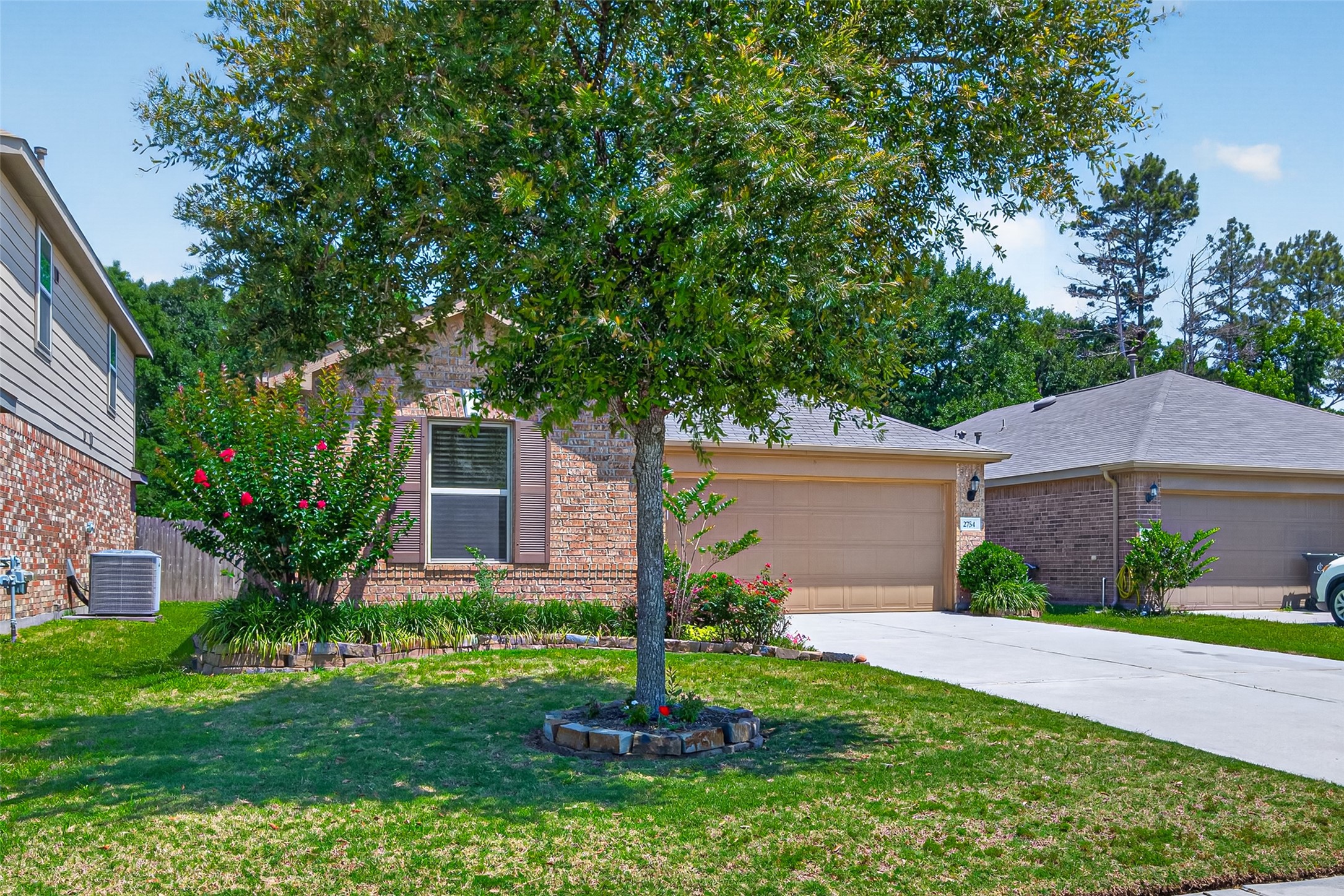 2754 Cayden Creek Way Conroe, TX 77304 - Photo 38 of 40 a front view of a house with a yard and a tree