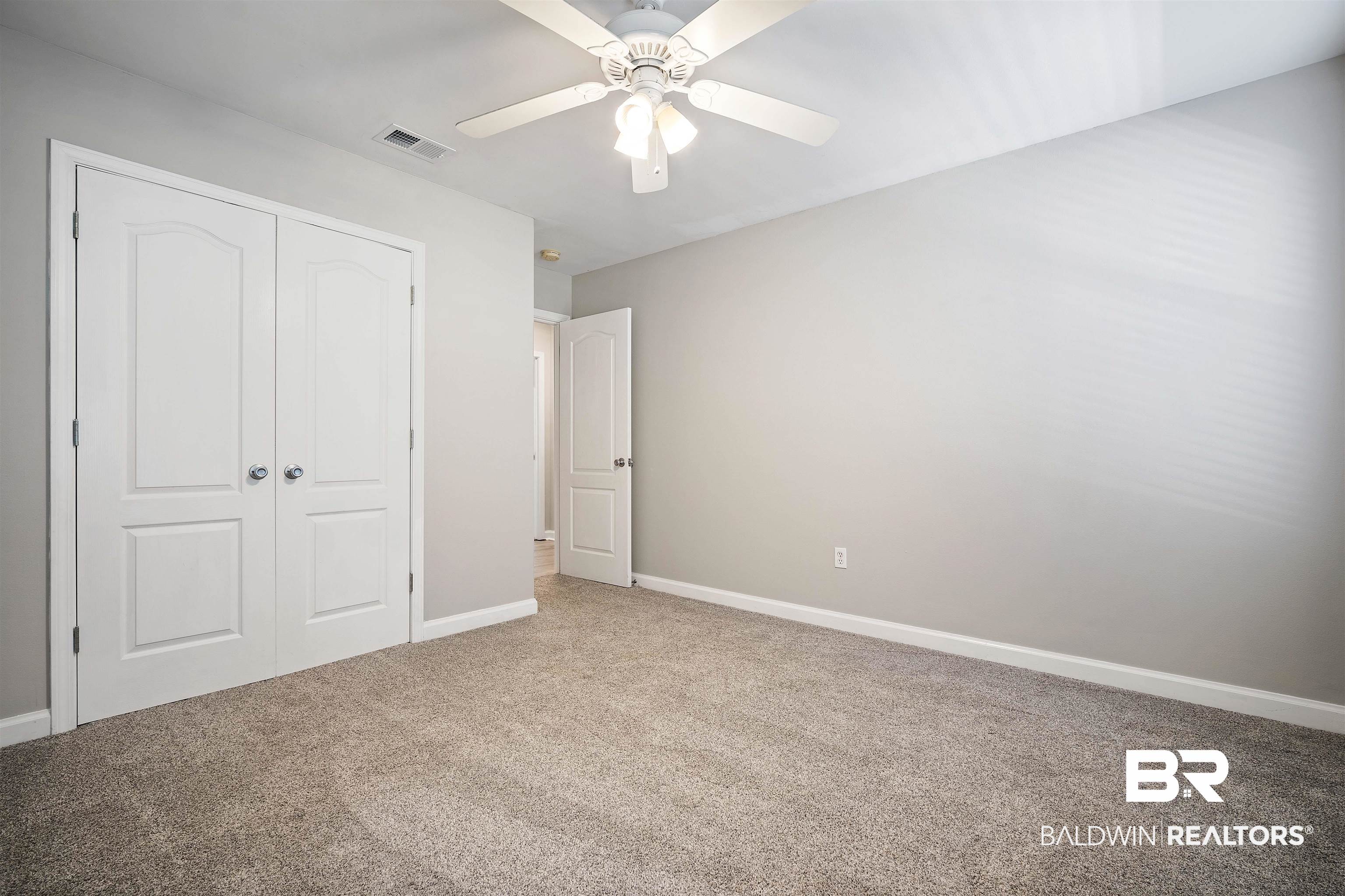3010 Drag Strip Lane Coden, AL 36523 - Photo 27 of 44 Unfurnished bedroom featuring ceiling fan, a closet, and carpet floors