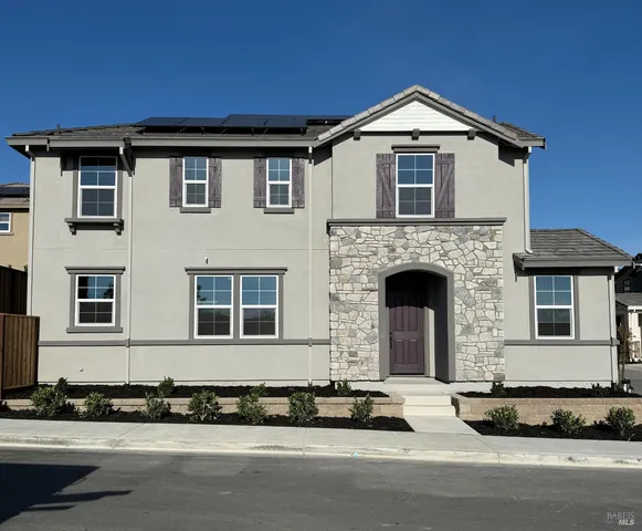 a front view of a house with a garden and garage