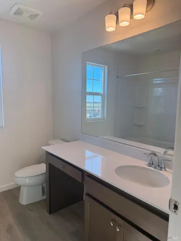 a bathroom with a sink a toilet and a mirror