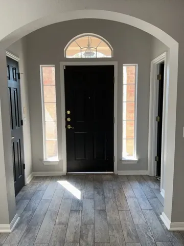 an empty room with window and wooden floor