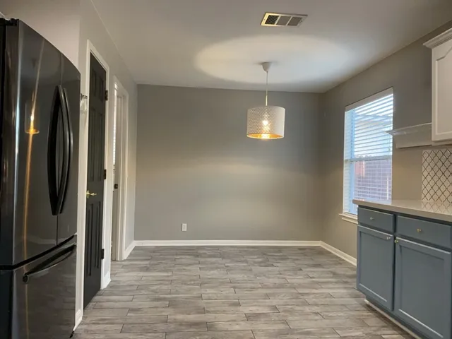a view of a refrigerator in kitchen and wooden floor
