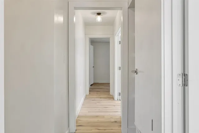 a view of a hallway with wooden floor and closet