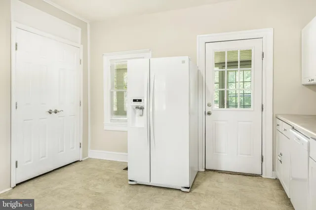 a kitchen with white cabinets and a window