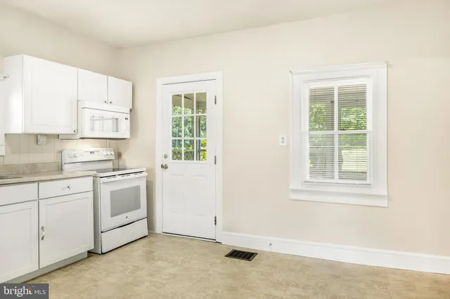 a kitchen with granite countertop white cabinets white stainless steel appliances with a sink and dishwasher