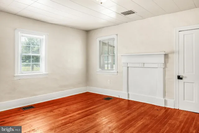 an empty room with wooden floor and a window