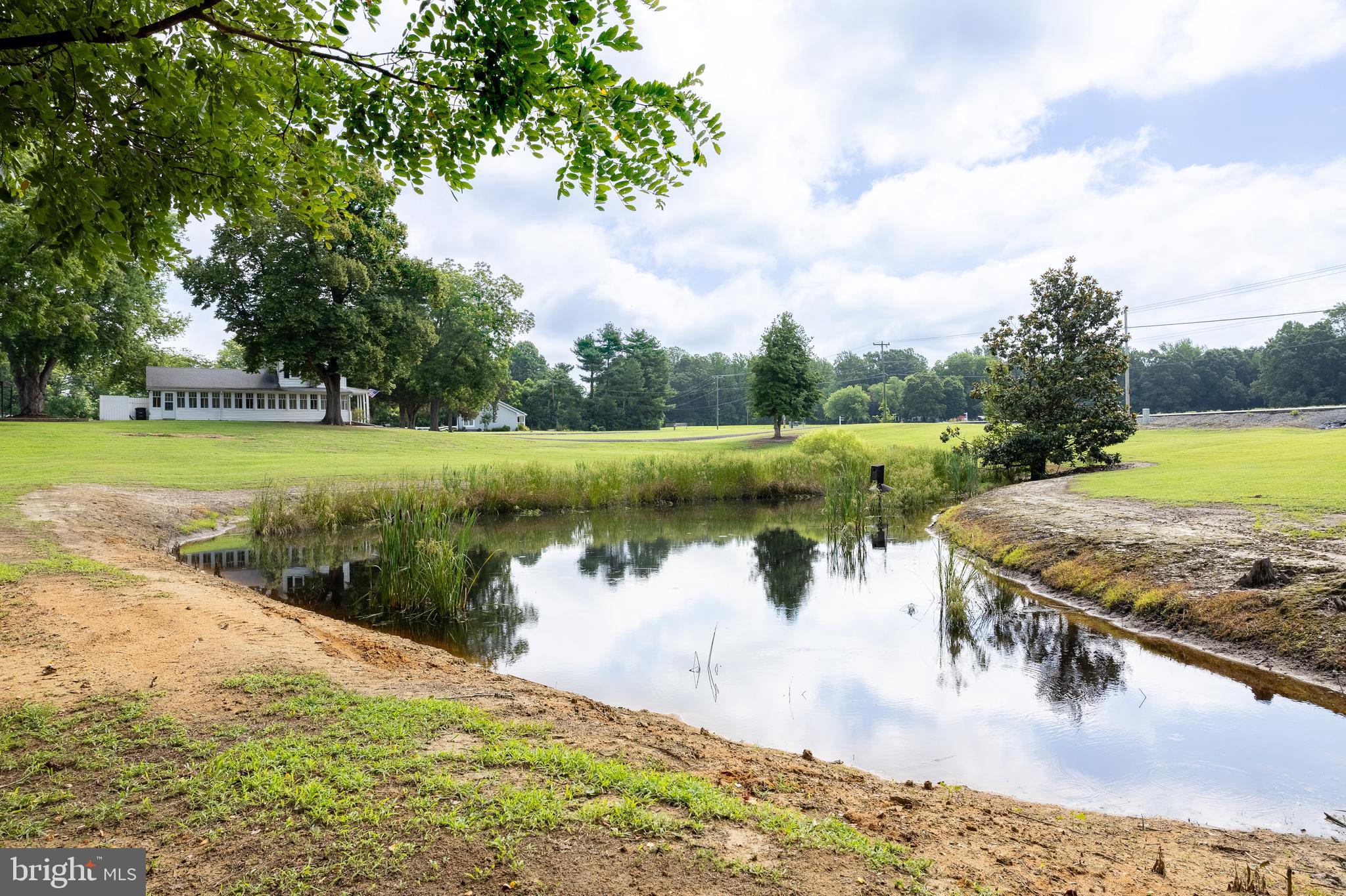 10287 Dahlgren Road King George, VA 22485 - Photo 33 of 54 a view of a lake with a yard and trees in the background
