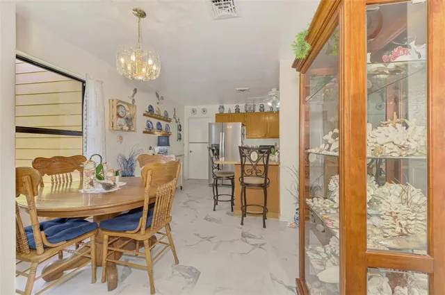 a dining room with furniture a chandelier and window