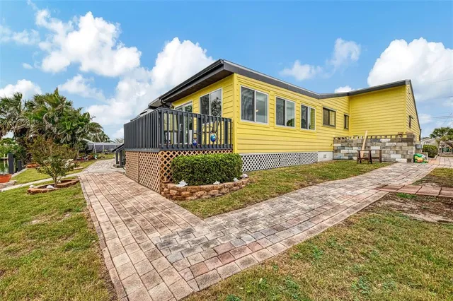 a view of a backyard with table and chairs potted plants and lake view