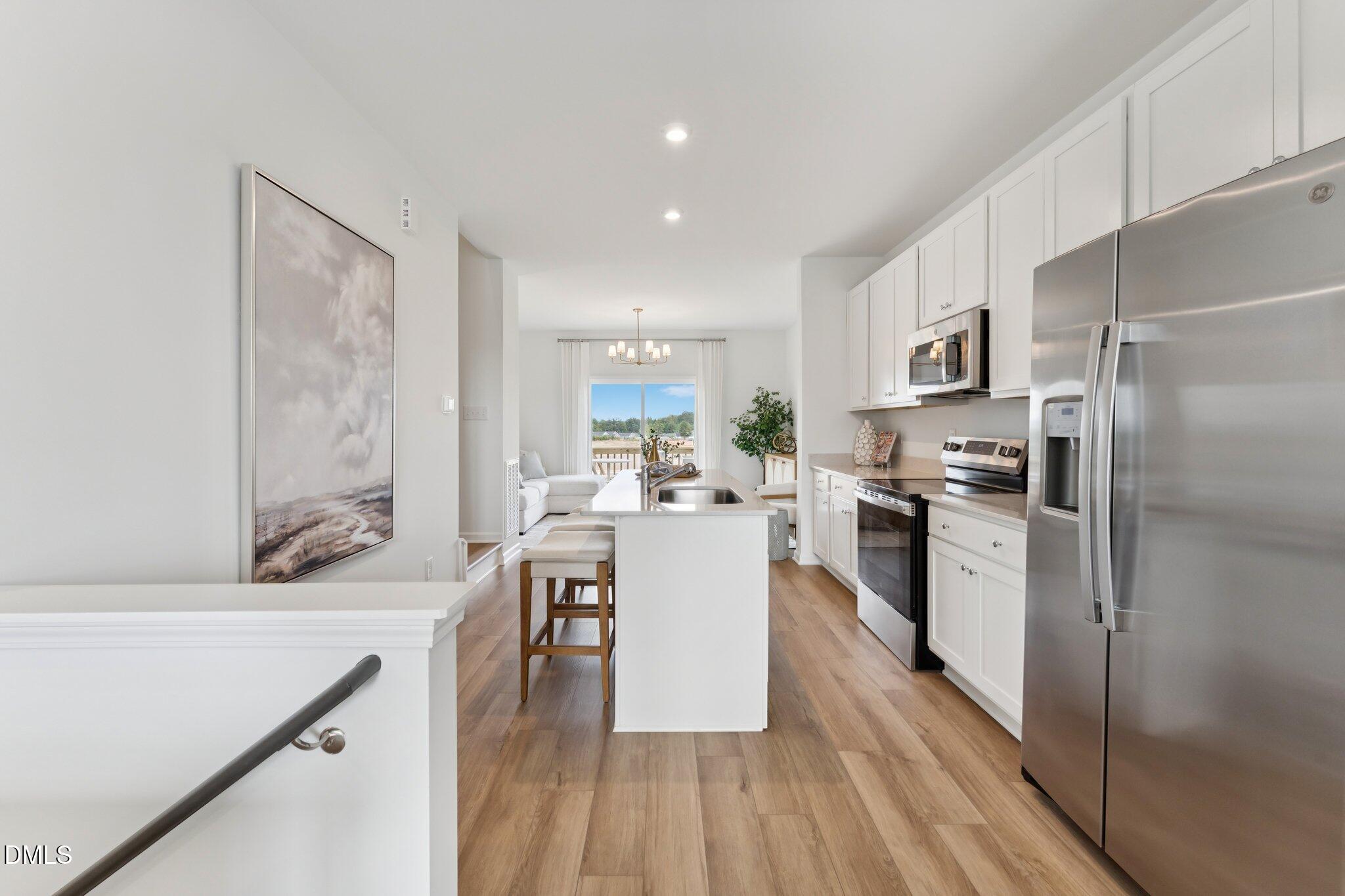 3104 Bomore Road Raleigh, NC 27610 - Photo 12 of 34 a kitchen with a refrigerator a sink and a stove top oven