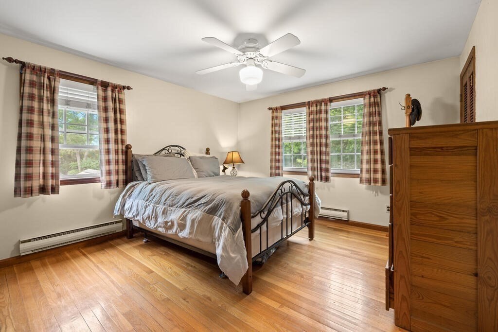 155 Main Street Winchester, MA 01890 - Photo 16 of 35 a bedroom with a bed lamp and a large window with wooden floor