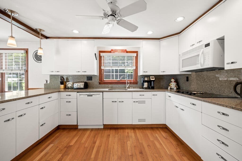 155 Main Street Winchester, MA 01890 - Photo 10 of 35 a large kitchen with granite countertop white cabinets stainless steel appliances a sink and a window