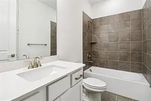 a bathroom with a sink toilet vanity and shower