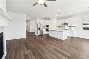 a view of kitchen view wooden floors appliances and cabinets